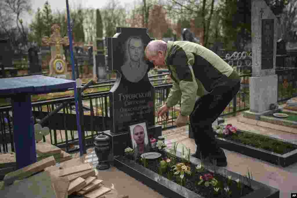 Oleksandr Turovskyi cuida la tumba de su hijo en Bucha, Ucrania, el sábado 30 de marzo de 2024. Dos años después que las fuerzas rusas se retiraron.