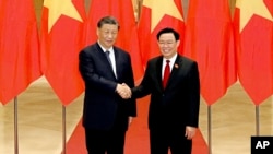 FILE - Chinese President Xi Jinping, left, and Vietnamese Chairman of the National Assembly Vuong Dinh Hue pose for a photo at the national assembly in Hanoi, Vietnam, Dec. 13, 2023.