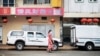 FILE - A woman walks in Cyrildene, also known as Johannesburg's China Town, South Africa, Feb. 07, 2020.