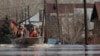 Russian Emergency Situation Ministry rescuers ride a boat to help local residents during evacuations from a flooded area in Orenburg, Russia, on April 11, 2024.