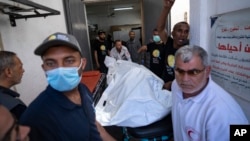 Members of the World Central Kitchen aid group transport the body of one of the six foreign aid workers who were killed in an Israeli strike, at a hospital morgue in Rafah, April 3, 2024.