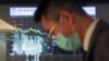 资料照：一名男子站在台湾证券交易所的电子屏幕前。（2023年3月20日）