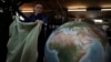 Peter Bellerby, the founder of Bellerby & Co. Globemakers, covers a globe at his studio in London, Britain, Feb. 27, 2024.