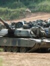 FILE - US M1A1 Abrams tanks block a path at a training range in Paju, near Demilitarized Zone (DMZ), 50 kilometer north of Seoul, on June 9, 2003. 