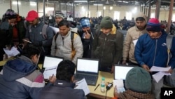 FILE - Indian workers to be hired for jobs in Israel submit their forms during a recruitment drive in Lucknow, India, Jan. 25, 2024. In the event of a war in the Middle East, Indian workers will be the most affected and remittances will stop.