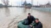 This photo released by the Russian Emergency Situations Ministry on April 6, 2024, shows rescuers wading across a flooded street on their way to evacuate residents in the Orenburg region, southeast of the southern tip of the Ural Mountains, Russia.
