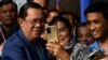 Cambodia's Prime Minister Hun Sen (L) takes selfies with people during a groundbreaking ceremony for the construction of a 135km expressway from the capital Phnom Penh to Bavet city in Svay Rieng province on the Cambodia-Vietnam border, in Phnom Penh on June 7, 2023.