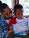 Adriane Burnett reads to her son Karter Robinson in Birmingham, Alabama, April 14, 2024.