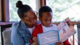 Adriane Burnett reads to her son Karter Robinson in Birmingham, Alabama, April 14, 2024.