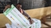 Um funcionário eleitoral prepara um boletim de voto na escola primária pública de Hedzranawoe, em Lomé, a 29 de abril de 2024, durante as eleições legislativas do Togo.