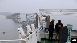 Petugas dari Dewan Transportasi dan Keselamatan Nasional (NTSB) melakukan penyelidikan di atas kapal kargo Dali yang menabrak dan meruntuhkan Jembatan Francis Scott Key di Baltimore, Rabu, 27 Maret 2024. (Peter Knudson/NTSB via AP)