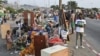Des habitants expulsés se rassemblent dans la rue avec leurs biens dans le quartier Boribana d'Attecoube à Abidjan, après la démolition de leurs maisons le 26 février 2024. (Photo d'Issouf SANOGO / AFP)