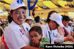 Ms. Sorn Phearum, a member of the Women's Movement of the Candlelight Party in Sangkat Lolok Sor, Pursat City, Pursat Province, carries her baby as she attends the Extraordinary Congress of the Candlelight Party in Siem Reap province, on February 11, 2023. (Kann Vicheika/VOA Khmer)