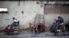 Los lustradores de zapatos asisten a los clientes a lo largo de una calle en Santiago de Cuba. Una imagen tomada el 19 de septiembre de 2015. El gobierno cubano anunció el 4 de abril de 2024 sobre la distribución de alimentos en la provincia donde hubo protestas.