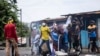 Des partisans de l'opposition détruisent une image publicitaire du président sortant des Comores Azali Assoumani, lors d'une manifestation à Moroni le 17 janvier 2024, suite à l'annonce des résultats de l'élection présidentielle.