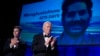 Host Colin Jost, left, and President Joe Biden applaud as an image of Austin Tice, an American journalist detained in Syria, appears on screen at the White House Correspondents' Association Dinner, April 27, 2024, in Washington. 