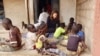 Audrey Gray, recipient of a Kim Wall Memorial Fund grant, sits with children in Senegal as they sort peanuts to sell. The American journalist was in Senegal covering climate adaption measures on Jan. 4, 2019. (Photo courtesy of Audrey Gray)