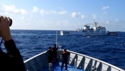 菲律賓海岸防衛隊發布照片顯示，一艘中國海警船（上）正在有爭議的南中國海阻攔一艘菲律賓政府船隻登陸鐵線礁（Sandy Cay ）。 （2024年3月21日）