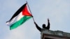 A protester waves a Palestinian flag above Hamilton Hall on the campus of Columbia University in New York, April 30, 2024.
