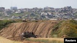 An Israeli tank holds a position, amid the ongoing conflict between Israel and the Palestinian Islamist group Hamas, near the Israel-Gaza border, in Israel, March 26, 2024.