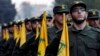 جنگجویان گروه حزب‌الله لبنان در هنگام اجرای رسم گذشت نظامی