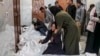 2024年3月5 日，在加沙地带南部汗尤尼斯的欧洲医院太平间，巴勒斯坦人在以色列轰炸中丧生的亲属尸体旁边哀悼。（法新社照片）