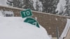 Una señal de carretera cubierta de nieve durante la tormenta, Truckee, California.