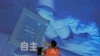 一名工人在上海舉辦的世界人工智能大會上檢視中國科技公司中科曙光展示的芯片和“自主” 字樣的螢幕。 （2023年7月5日）