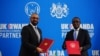 Secretário do Interior britânico, James Cleverly (esq), e o ministro das Relações Exteriores de Ruanda, Vincent Biruta, (dir) trocam documentos após assinarem um novo tratado, em Kigali, 5 de dezembro de 2023