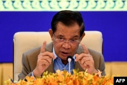 FILE - Cambodia's Prime Minister Hun Sen gestures during a press conference at the Peace Palace in Phnom Penh on September 17, 2021, as the country begins vaccinating children aged between six and 12. (Photo by TANG CHHIN Sothy / POOL / AFP)