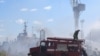 На фотографии, опубликованной Telegram-каналом Одесского горсовета 24 июля 2022 года, видно, как украинские пожарные тушат горящий катер в Одесском порту после попадания ракет 23 июля 2022 года