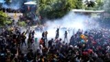 Police use tear gas to disperse the protesters who stormed the compound of prime minister Ranil Wickremesinghe 's office, demanding he resign after president Gotabaya Rajapaksa fled the country amid economic crisis in Sri Lanka, July 13, 2022. (AP Photo/Eranga Jayawardena)