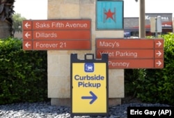A sign directs shoppers to curbside pickup at North Star Mall in San Antonio, Texas, April 24, 2020. (AP Photo/Eric Gay)