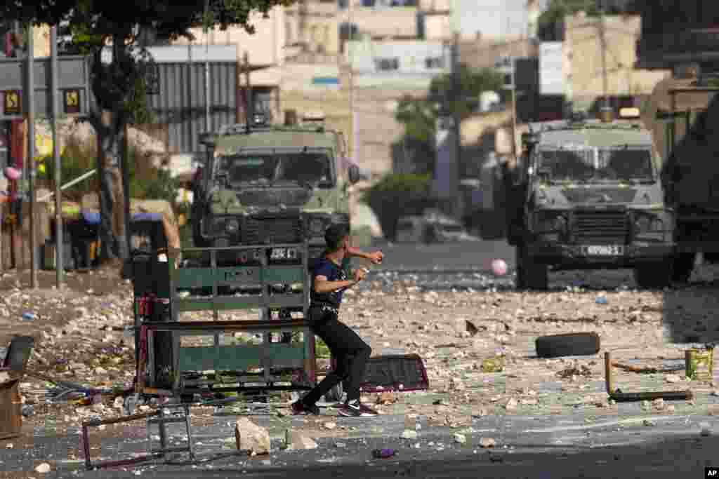 Palestinian demonstrators clash with the Israeli army while forces carry out an operation in the West Bank town of Nablus.