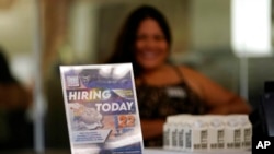 FILE - A hiring sign is placed at a booth for prospective employers during a job fair Sept. 22, 2021, in the West Hollywood section of Los Angeles. 