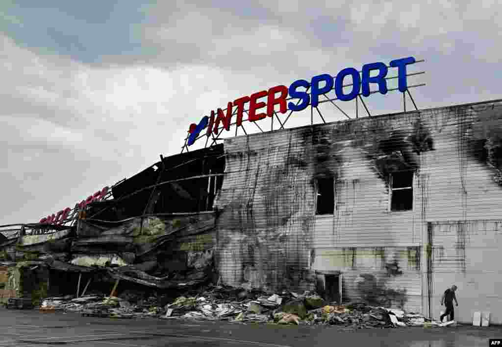 An employee looks through the debris of a destroyed French sporting goods retailer, Intersport, at a shopping mall in Bucha, Kyiv region, amid Russia's invasion of Ukraine.