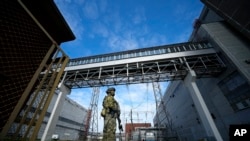 FILE - A Russian serviceman guards an area of the Zaporizhzhia Nuclear Power Station in territory under Russian military control, southeastern Ukraine, May 1, 2022. Russia and Ukraine have trade blame over shelling of the plant.
