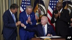 Predsednik SAD Džo Bajden potpisuje zakon o klimatskim promenama i zdravstvenoj zaštiti u prisustvu demokratskih senatora (Foto: AP/Susan Walsh)