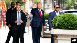 도널드 트럼프(가운데) 전 미국 대통령이 10일 뉴욕주 법무장관실에 가는 도중 주먹을 쥐어 보이고 있다. 
