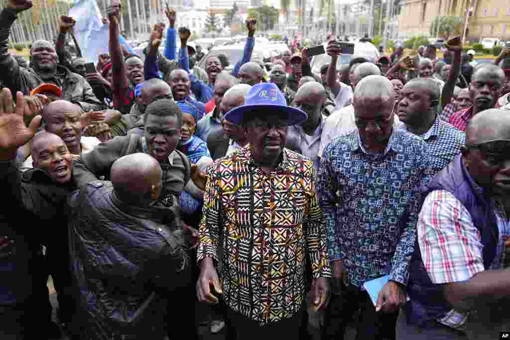 Kenyan presidential candidate Raila Odinga, center, arrives prior to delivering an address to the nation at his campaign headquarters in Nairobi, Kenya. Kenya is calm a day after Deputy President William Ruto was declared the winner of the narrow presidential election. (AP Photo/Ben Curtis)