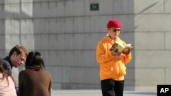 FILE - In this December 2013, photo, Xiao Jianhua, a Chinese-born Canadian billionaire, reads a book outside the International Finance Centre in Hong Kong.