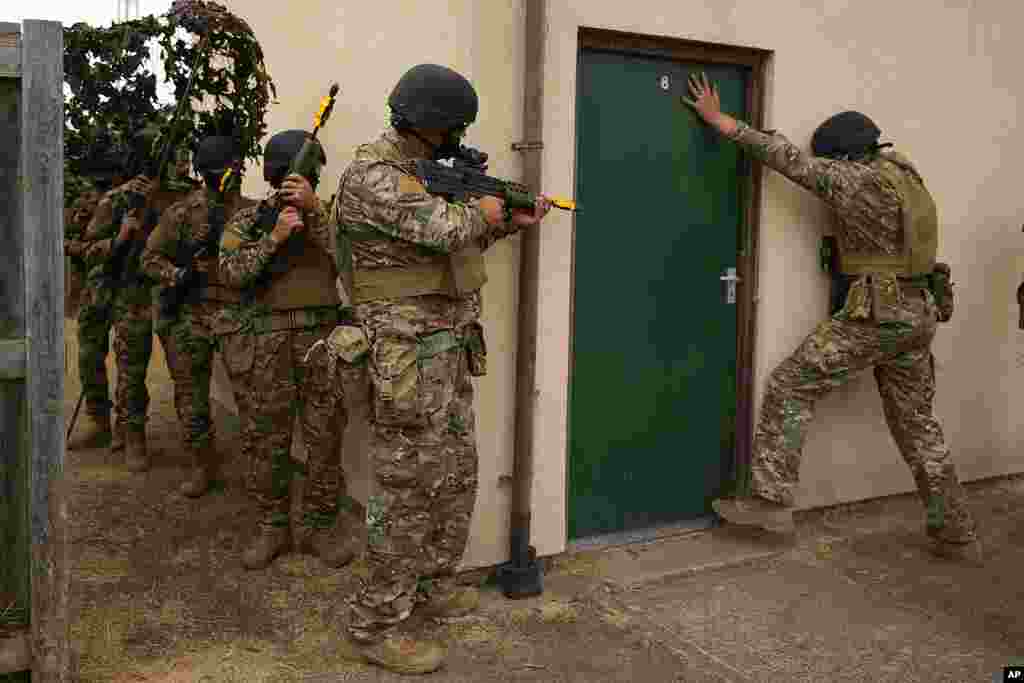 Ukrainian volunteer military recruits take part in an urban battle exercise whilst being trained by British Armed Forces at a military base in Southern England.