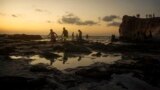 Egyptians on holiday walk at Cleopatra Beach, in the Mediterranean city of Marsa Matrouh, 270 miles (430 kilometers) northwest of the capital, Cairo, Egypt, Wednesday, Aug. 10, 2022. (AP Photo/Amr Nabil, File)