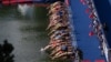 Athletes dive into the water at the start in the women's Elite Triathlon at the Olympic Park in Munich, Germany.