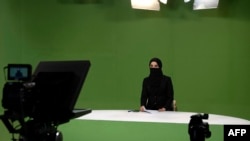 FILE - Masheed Barzz, an Afghan presenter for 1TV channel, appears on camera with her face covered by a veil, in Kabul on May 25, 2022. The Taliban have mandated that female news presenters and guests cover their faces except for the eyes on television.