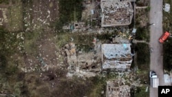 El cráter de un ataque con cohetes rusos el viernes por la noche se ve junto a casas dañadas en Kramatorsk, región de Donetsk, este de Ucrania, el 13 de agosto de 2022.