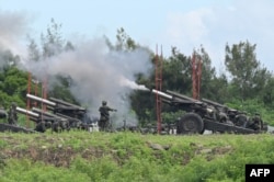 Taiwan military soldiers fire the 155-inch howitzers during a live fire anti landing drill in the Pingtung county, southern Taiwan on August 9, 2022. (Photo by Sam Yeh / AFP)