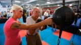 FILE - Parkinson's patient Jim Coppula gets some pointers from his daughter Ellen as he works out on a bag during his Rock Steady Boxing class in Costa Mesa, California September 18, 2013. (REUTERS/Mike Blake) 