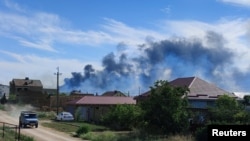 Smoke rises after explosions were heard from the direction of a Russian military airbase near Novofedorivka, on Ukraine’s Crimean Peninsula, Aug. 9, 2022.