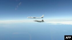 FILE - This NORAD handout photo shows North American Aerospace Defense Command F-22 Raptors as they successfully completed two intercepts of Russian bomber aircraft formations entering the Alaskan Air Defense Identification Zone on June 16, 2020.